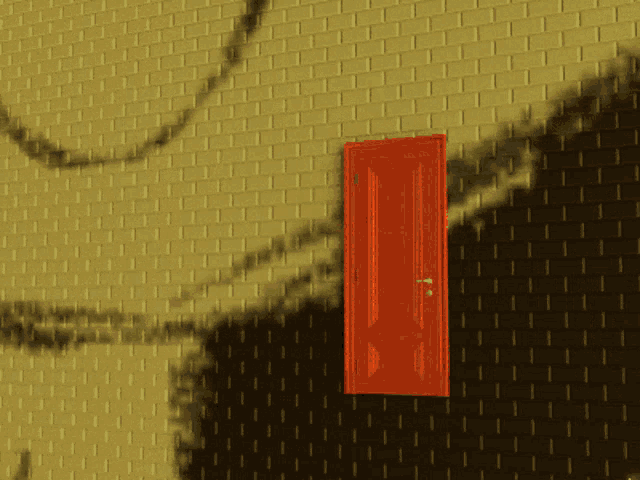 an orange door with a drawing of a face on the wall