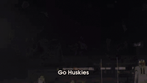 a blurred image of a football team with the words go huskies on the bottom