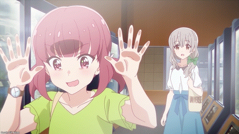 a girl in a green shirt is waving at another girl in a white shirt with a bag that says universe