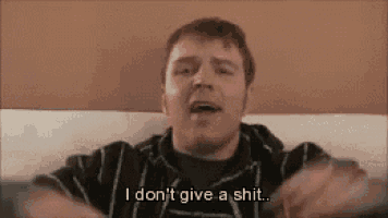 a man is sitting on a couch making a funny face and saying `` i don 't give a shit ... ''