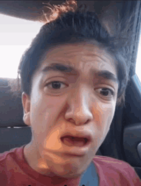 a young man is making a funny face in a car