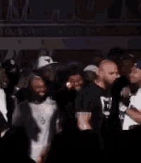 a group of people are standing in a dark room and dancing .