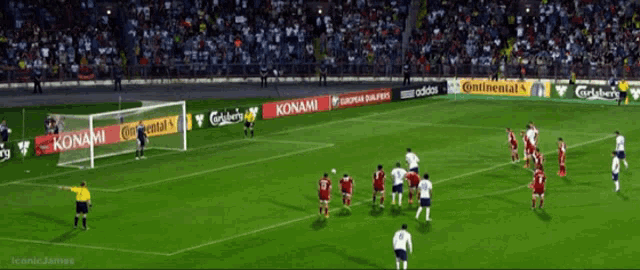 a soccer game is being played in a stadium with advertisements for konami and adidas