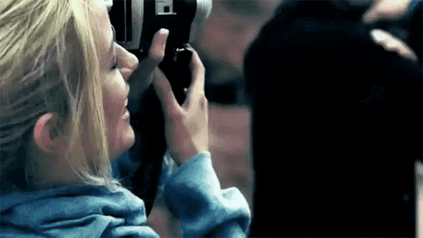 a woman is taking a picture with a camera that has the letter f on it