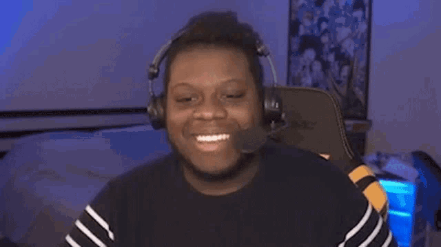 a man is wearing headphones and a microphone and smiling .