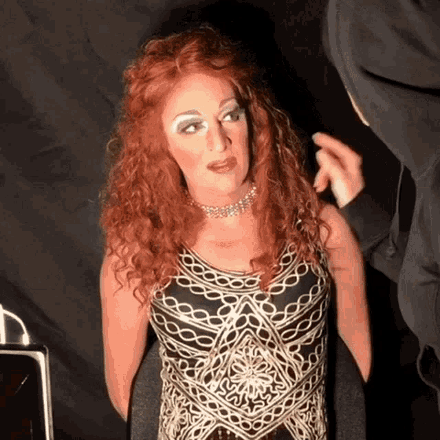 a woman with red hair and a black and gold dress