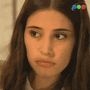 a close up of a woman 's face with a hair clip in her hair that has three dots on it