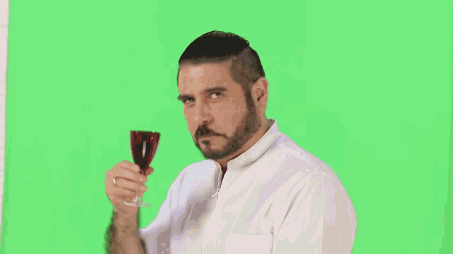 a man with a beard is holding a glass of wine