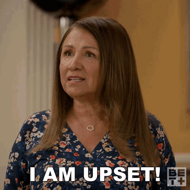 a woman says " i am upset " in a floral top