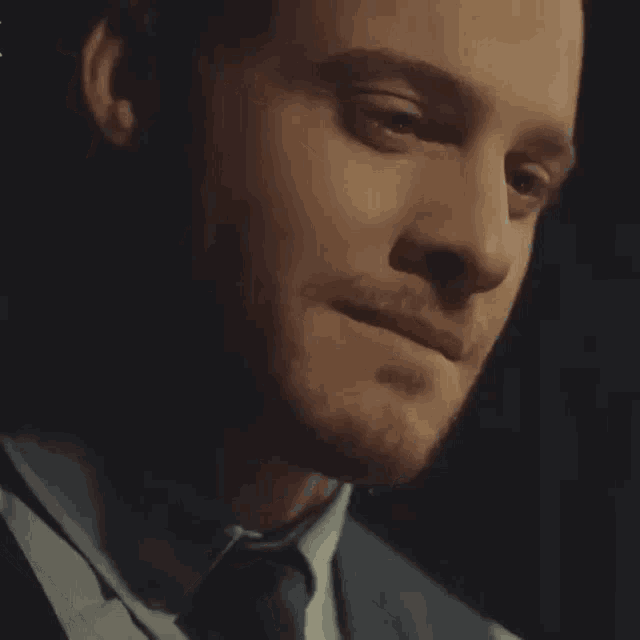 a close up of a man in a suit and tie making a funny face .