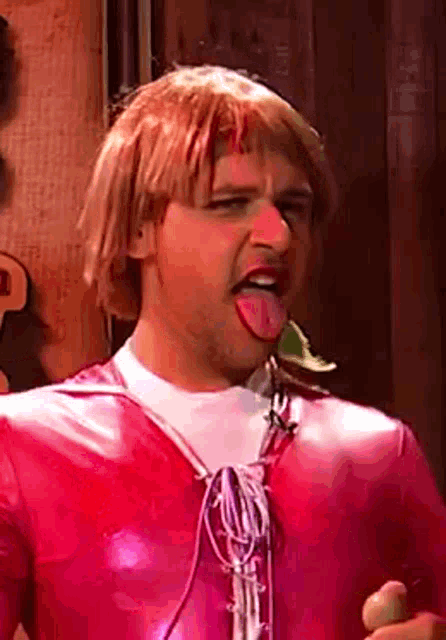 a man in a pink costume sticking his tongue out .