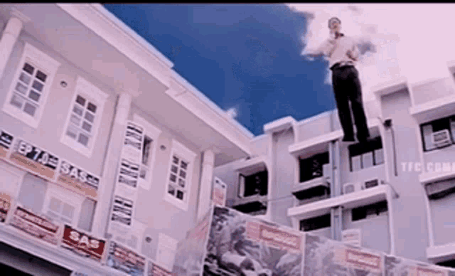 a man is standing on the side of a building with a sign that says sas