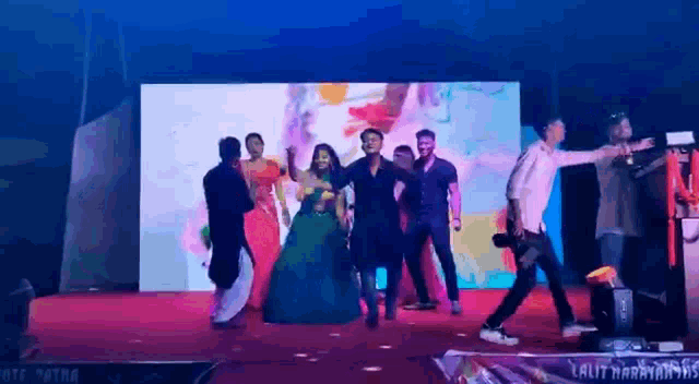 a group of people are dancing on a stage at a party .