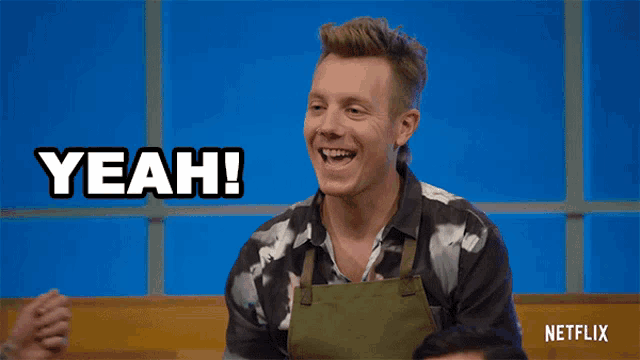 a man in an apron is laughing and says yeah