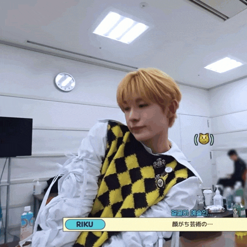 a man wearing a yellow and black vest with the name riku written on the bottom