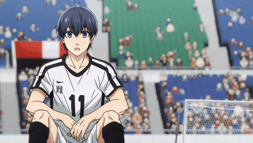 a soccer player with the number 11 on his shirt sits on the field