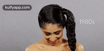 a woman with a braided ponytail is smiling in the 1980s .