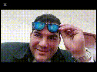 a man wearing sunglasses and a watch with the letter b on the bottom right