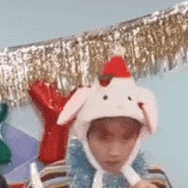 a person wearing a white bunny hat with a santa hat on it .