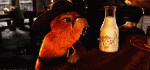 a cat in a cowboy hat is drinking milk from a glass bottle