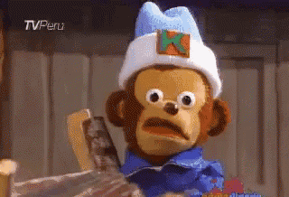 a stuffed monkey wearing a blue shirt and a white hat with an x on it