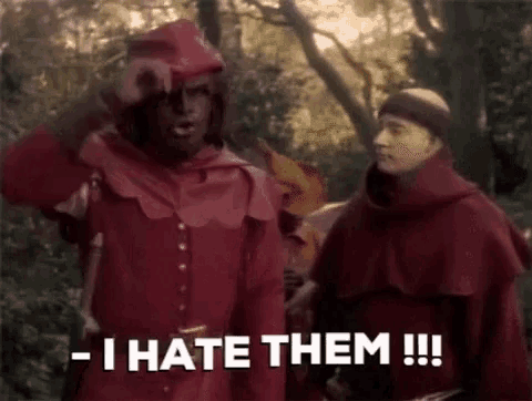a man in a red robe is standing next to another man in a red robe and saying `` i hate them ! ''