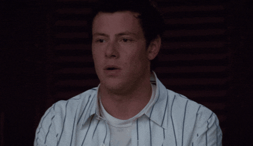 a man in a striped shirt looks surprised