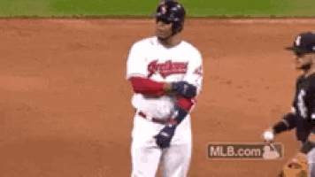 a baseball player is standing on a field with a mlb.com logo in the background .