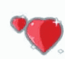 two red hearts are sitting next to each other on a white surface .