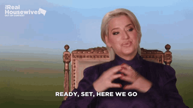 a woman sitting in a chair with the words ready set here we go