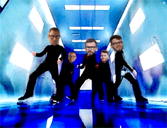 a group of men are dancing in a hallway with their faces on their bodies