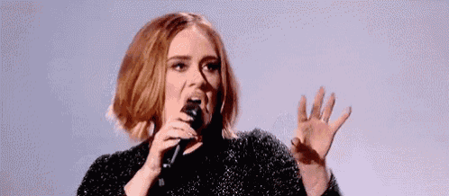 a woman is singing into a microphone with her mouth open .