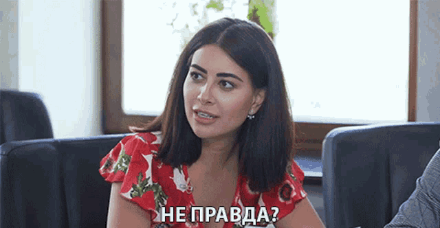 a woman in a red dress is sitting in front of a window with the words he pravda written below her
