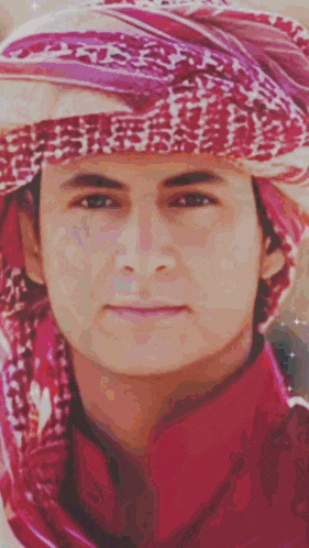 a man wearing a head scarf and a red shirt has the word kings on the bottom left