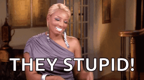a woman in a purple dress is sitting in a living room with the words `` they stupid '' written on the screen .