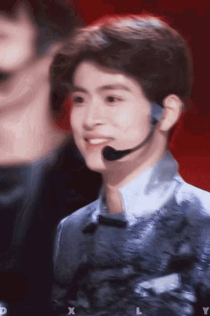a young man wearing a microphone and smiling