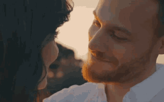 a man and a woman are kissing each other .