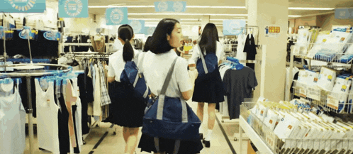 a group of girls are shopping in a store with a sign above them that says ' cool '