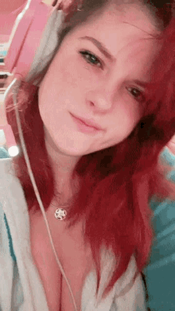 a woman with red hair is wearing headphones