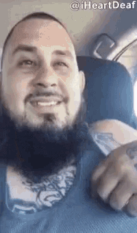 a man with a beard is sitting in the back seat of a car .