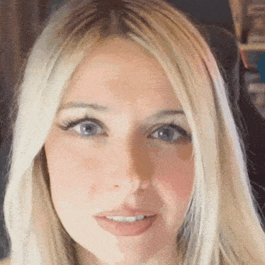 a close up of a woman with blonde hair and blue eyes