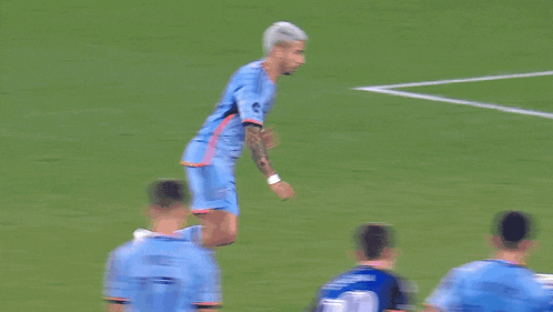 a soccer goalie jumps to catch a soccer ball in front of an ad for pepsi