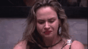 a woman with long hair is crying with her eyes closed and her mouth open .