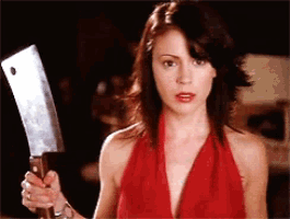a woman in a red dress holds a large knife