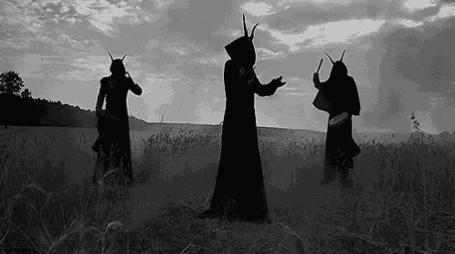 three people with horns are standing in a field