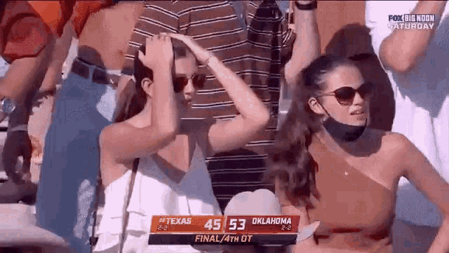 a crowd of people watching a football game between texas and oklahoma .