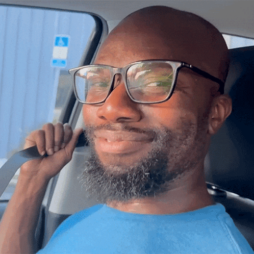 a man wearing glasses is sitting in a car