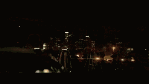 a man is driving a car at night with a red light behind him