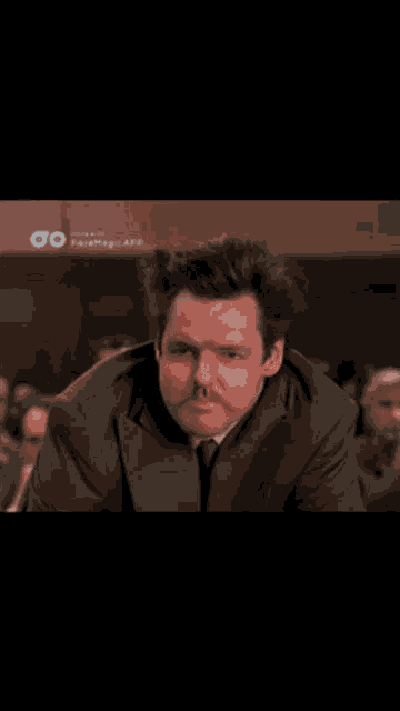 a phone screen shows a man in a suit and tie and says today at the top