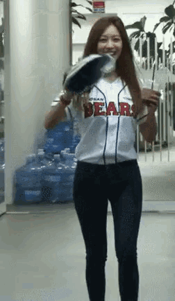 a woman in a bears jersey is holding a baseball bat